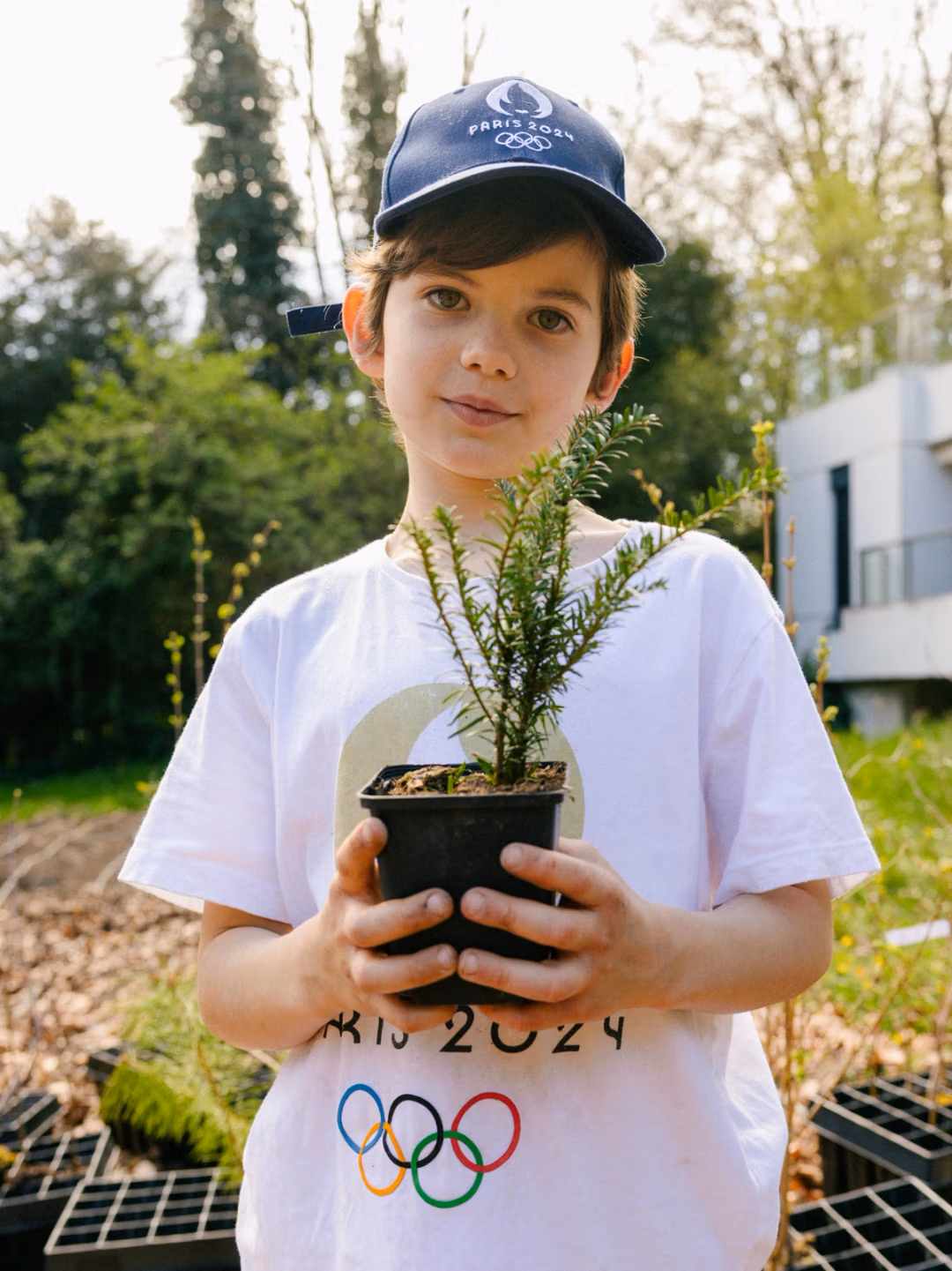 A young participant holding a plant during a community planting