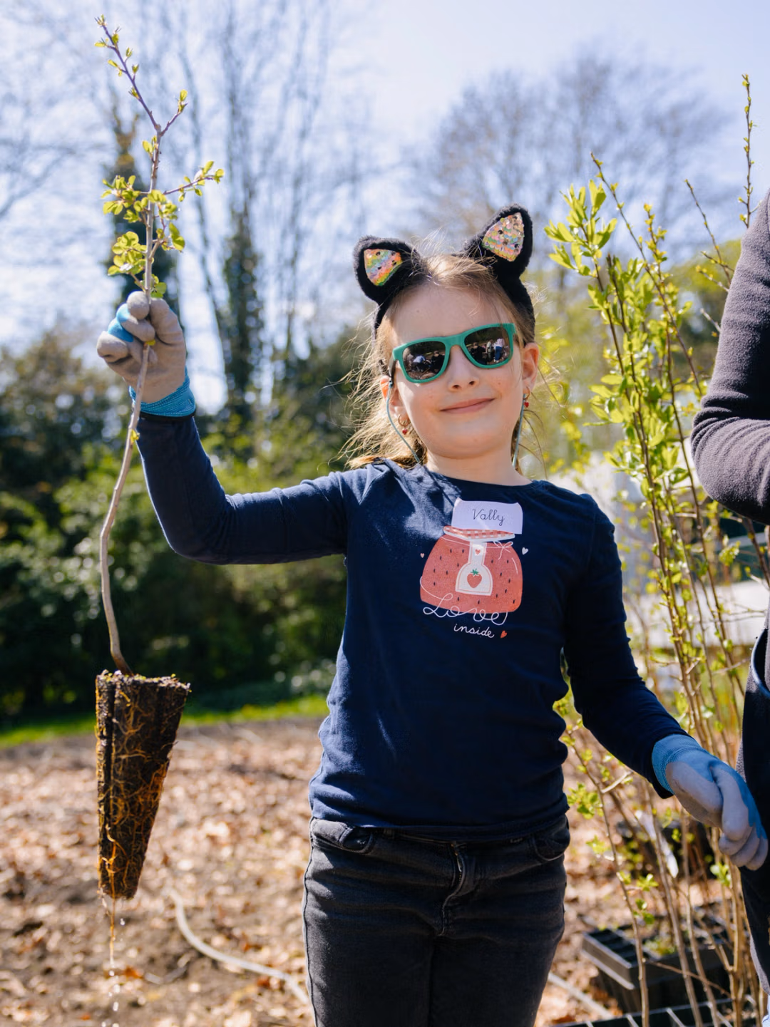 Girl holding a plant during a SUGI Foundation planting